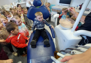 Chłopiec na fotelu dentystycznym.