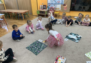 Dziewczynka układa odpowiednią ilość guzików.