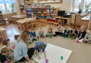 Chłopiec ustawia kubki według instrukcji