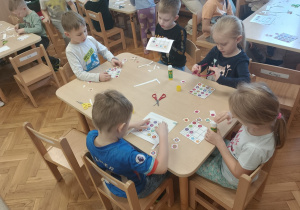 Dzieci wyklejają obrazek według wzoru