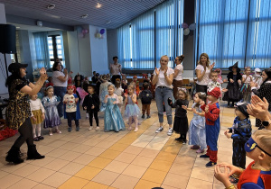 04 Dzieci w przebraniach tańczą i klaszczą z paniami w kole