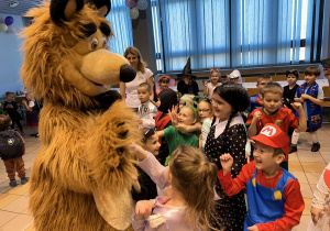 05 Dzieci w przebraniach witają się z animatorem w przebraniu misia