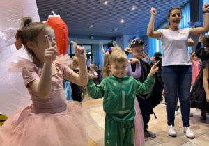 14 Dzieci w przebraniach tańczą unosząc ręce
