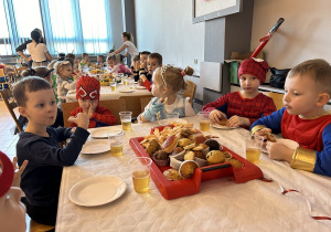 32 Dzieci przy stolikach jedzą słodkości