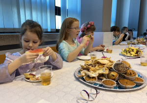 36 Dzieci przy stolikach jedzą owoce i słodycze