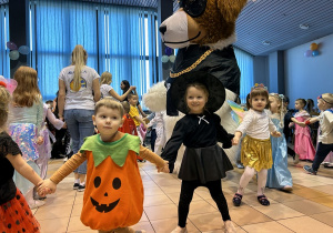 52 Dzieci tańczą w pociągu trzymając się za ręce w towarzystwie wielkiego psa