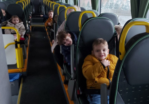 Dzieci siedzą w autobusie i pozują do zdjęcia