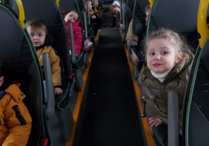 Dzieci siedzą w autobusie i pozują do zdjęcia