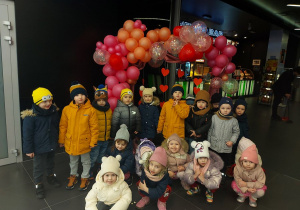 Przedszkolaki pozują do zdjącia na ściance walentynkowej