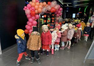 Przedszkolaki pozują do zdjącia na ściance walentynkowej