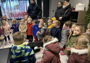 Dzieci uważnie słuchają pani i oglądają salon.