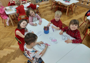 Dzieci kolorują malowanki walentynkowe.