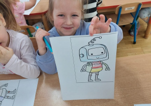 Dziewczynka pokazuje swoją pracę.
