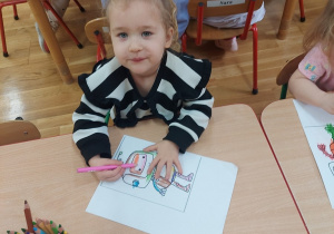 Dziewczynka koloruje robota.