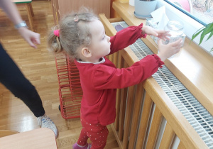 Dziewczynka odkłada słoik na ciepły grzejnik.
