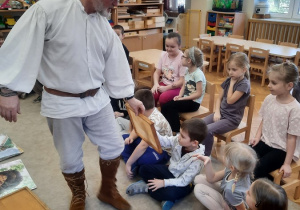 16 Pan pokazuje dzieciom ramkę z woskiem.