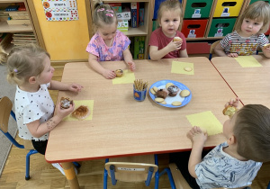 Dzieci zajadają się babeczkami.