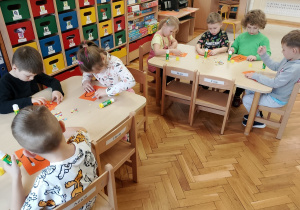 Dzieci przyklejają motylki na liczbę 10.
