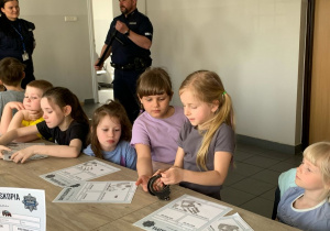 Dziewczynki oglądają kajdanki policyjne