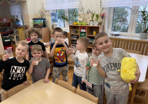 Dzieci trzymają mleko w kubeczkach.
