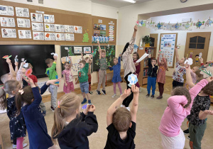 Dzieci tańczą z kwiatami.