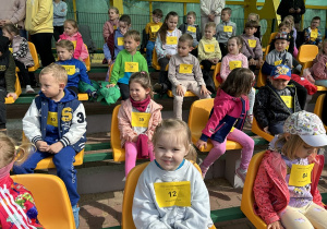 01 Dzieci siedzące na trybunach oczekują na rozpoczęcie zawodów.