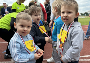 14 Chłopcy z grupy trzylatków stoją z medalami na szyjach.
