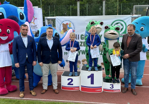 45 Chłopcy z grupy czterolatków na podium z medalami i dyplomami.