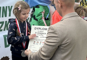 46 Dziewczynka z grupy pięciolatków odbiera dyplom i srebrny medal.