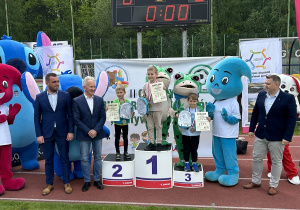 49 Chłopcy z grup pięciolatków na podium z medalami i dyplomami.