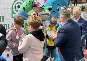 52 Chłopcy z grup sześciolatków odbierają medale i dyplomy stojąc na podium.