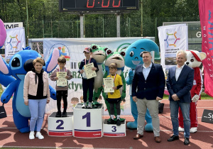 53 Chłopcy z grup czterolatków na podium z medalami i dyplomami.