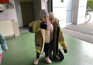 05 Dziewczynki z grupy Kropelek przymierzają kurtkę strażacką