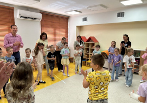 01. Dzieci z rodzicami biorą udział w zabawie ruchowej.