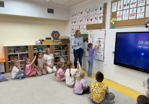 06. Dziewczynka zapisuje na tablicy literę.
