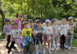 Grupa dzieci pozuje z dinozaurem.