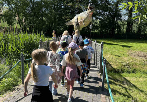 Dzieci idą obejrzeć dinozaura.