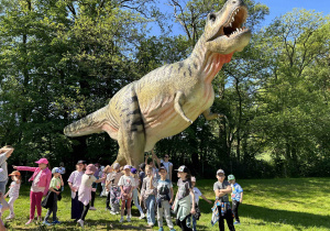 Dzieci i ogromny dinozaur.