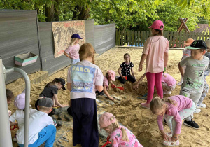 Dzieci z grupy Słoneczek odkopują szkielet dinozaura.