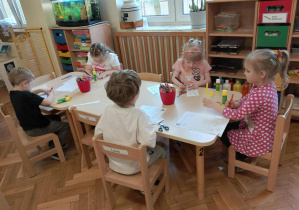 Dzieci pracują przy stoliczkach.