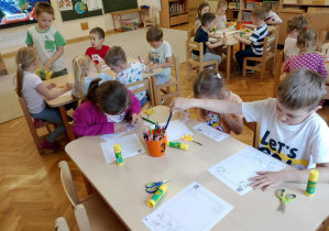 Dzieci pracują przy stoliczkach.