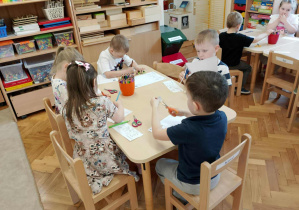 Dzieci pracują przy stoliczkach.
