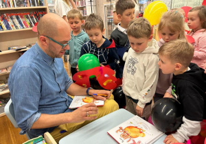 "Pan Poeta" wpisuje dedykacje do książek.