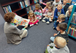 Bibliotekarka czyta dzieciom książkę.