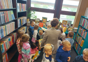Pani bibliotekarka prezentuje przedszkolakom dział dla dzieci.