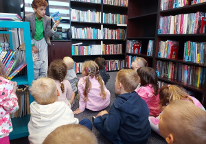 Pani bibliotekarka przekazuje dzieciom informacje na temat zasad korzystania z biblioteki.