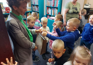 Przedszkolaki wręczają podziękowanie za wizytę w bibliotece.