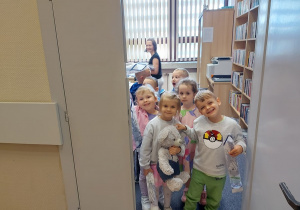 Zadowolone przedszkolaki wychodzą z biblioteki.