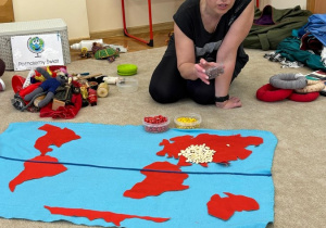Pani prezentuje dzieciom mapę i fasolki.