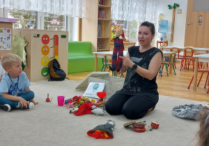 Pani prezentuje zabawki pochodzące z różnych zakątków świata.